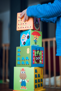 enfant qui fait une tour avec des cubes